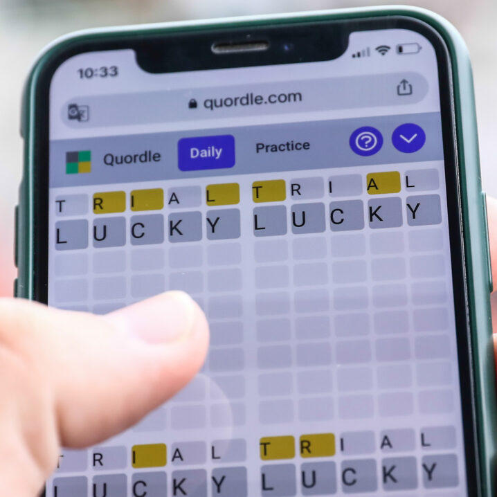 person playing word game quordle, a wordle clone, on iphone