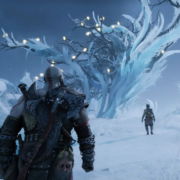 Kratos and Atreus walking towards a snow-covered tree from the God of War: Ragnarok story trailer.