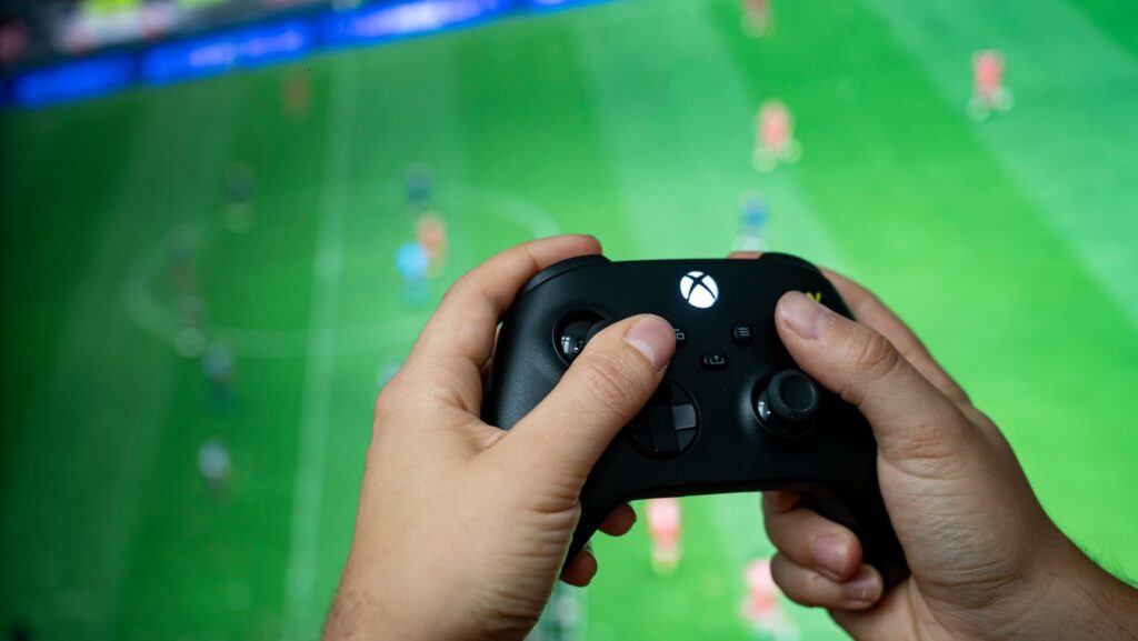 xbox controller being held playing a game of FIFA