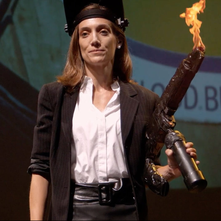 Nina Struthers holding a flamethrower from a Devolver Digital showcase.
