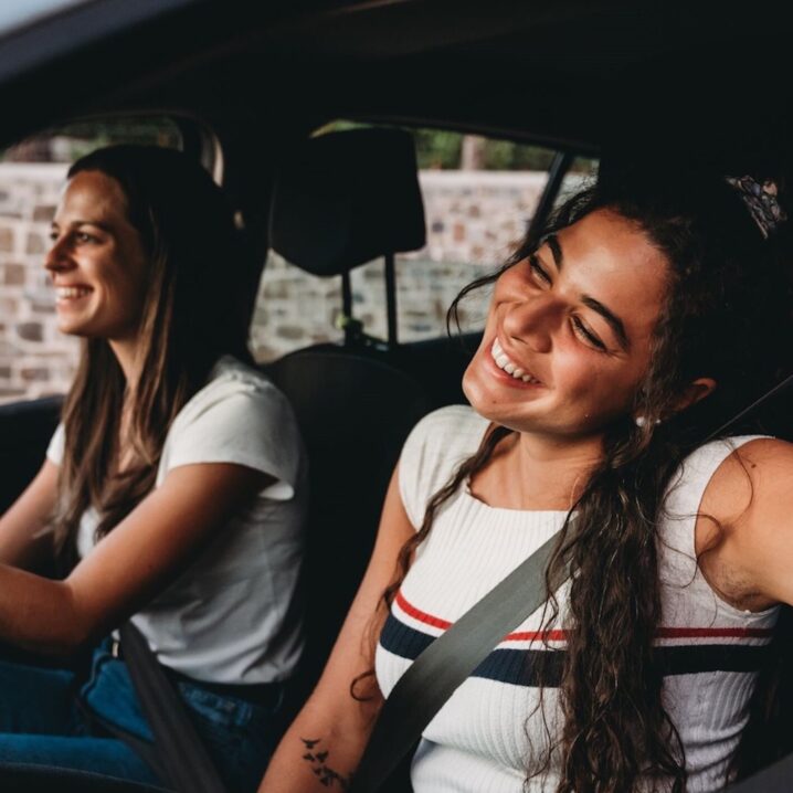 girls driving a car smiling