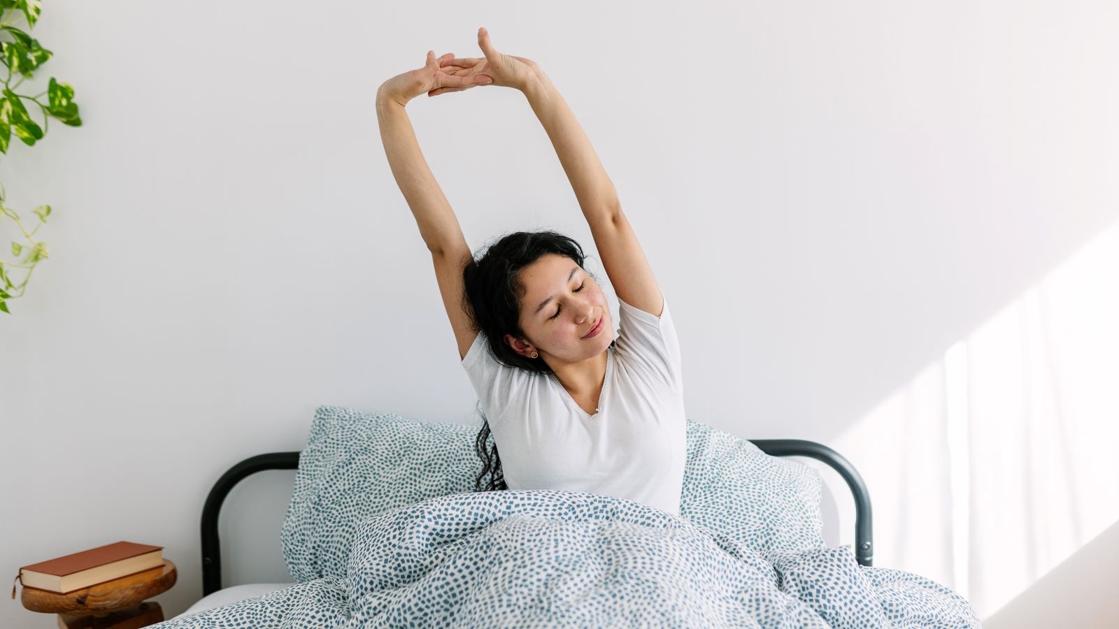 woman waking up in bed and stretching