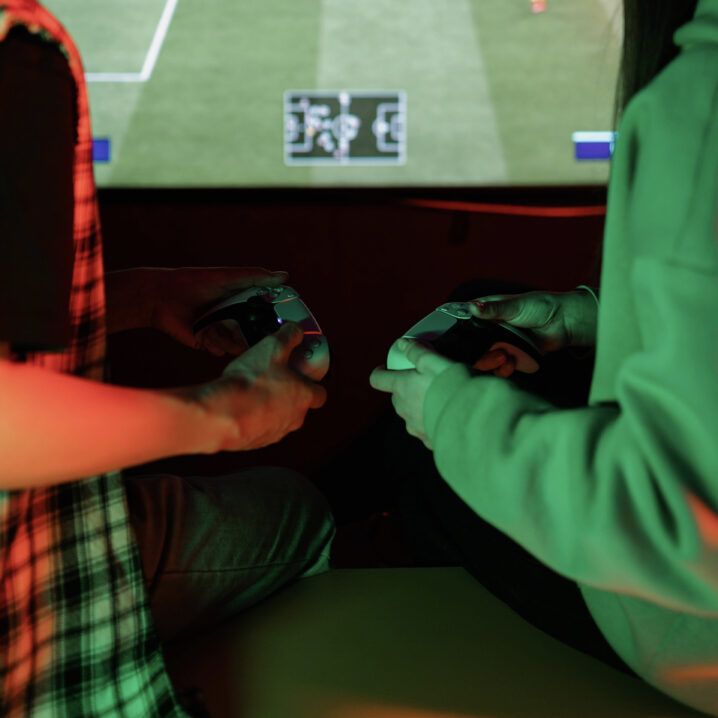 Two people playing FIFA on controllers